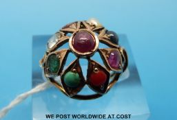 A yellow metal ring set with various stones including coral, turquoise, pearl,