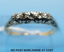 An 18ct gold ring set with five diamonds in a scrolling setting (size N/O)