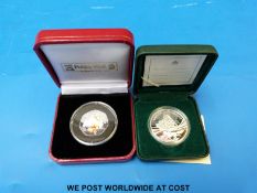 Two cased commemorative coins comprising a Canadian silver dollar for the 100th anniversary of the
