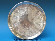 A Georgian hallmarked silver salver with engraved decoration raised on three feet (Ldn 1799),