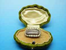 A gold mourning brooch set with hair within a border of seed pearls dated 1898 to reverse