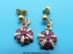 A pair of 9ct gold earrings set with rubies and diamonds in a floral cluster
