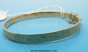 A 9ct gold bangle with chased decoration