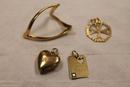 A 9ct gold card charm together with a yellow metal wishbone ring, a 9ct gold heart locket and a