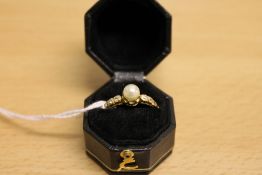 A pearl and diamond ring mounted in yellow metal.