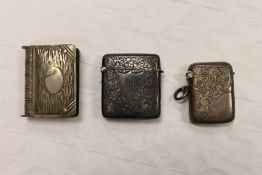 Two silver vesta cases, together with a white metal vesta case in the form of a book. (3)