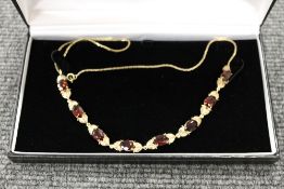 A 9ct gold necklace set with eight garne
