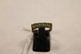 A 9ct gold emerald half hoop ring. CONDITION REPORT: Good condition.