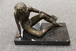 A bronze study of a man holding a book,
