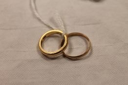 An 18ct gold wedding band, 4.3g, together with another yellow metal wedding band. (2) CONDITION