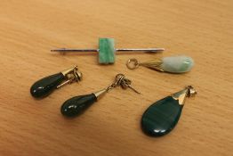 A pair of jade earrings in gold mounts,
