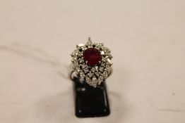 An 18ct white gold ruby and diamond cluster ring. CONDITION REPORT: Good condition. Set with