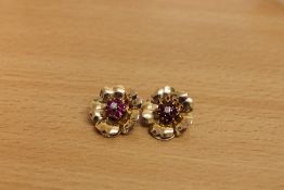A pair of ruby and diamond earrings, modelled as flowers.