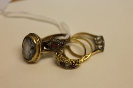 An 18ct gold three stone diamond ring, together with four further gem set rings in gold.