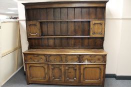 A Georgian style oak dresser with delft rack, width 190 cm.