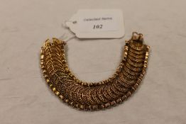 A yellow metal flexi-link bracelet with fan shaped filigree centres, 49g. CONDITION REPORT: Good