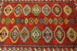 An Iranian wool carpet, on red ground, 175 cm x 206 cm.