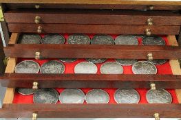 A mahogony coin cabinet containing forty eight coins, with examples of Victorian crowns, Georgian