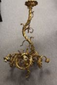 A nineteenth century lacquered brass ceiling light, with vigorous scrolling design on link chain.