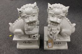 A pair of Chinese Blanc de Chine type figures depicting Fu dogs, impressed character mark to base,