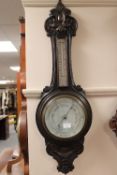 An Edwardian carved oak aneroid barometer.