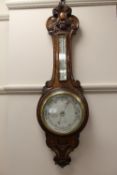 An Edwardian oak aneroid barometer.