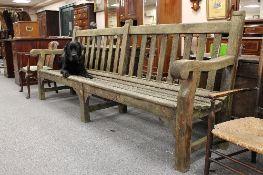 An early twentieth century wooden garden seat, width 243cm.