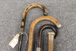 A collection of four white metal mounted walking sticks. (4) CONDITION REPORT: Good time aged