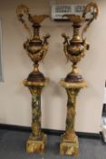 A pair of bronze and ormolu mounted urns, elaborately decorated with vines, each standing upon a