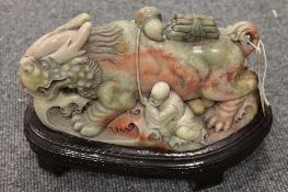 A carved chinese soap stone figure depicting a mythical beast with a man, length 24 cm.  CONDITION