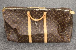 A Louis Vuitton travel bag, with two padlocks and keys, width 60cm.   CONDITION REPORT: Excellent