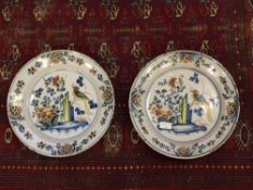 A pair of eigteenth century tin-glazed plates, diameter 34 cm.  (2)  CONDITION REPORT: Metal plate