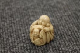 A nineteenth century ivory netsuke depicting two figures, signed, width 3 cm. CONDITION REPORT: Good