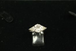 A diamond ring, the central diamond approximately 3ct, surmounted on each side by a triangular-cut