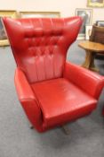 A mid twentieth century red vinyl three piece lounge suite together with a square footstool.