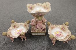 A continental gilded comport trio, mounted with cherubs and with hand painted floral decoration. (3)