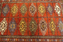 An Iranian wool carpet, on red ground, 174 cm x 124 cm.
