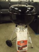 new and assembled Weber Charcoal barbecue with briquettes and barbecue cover
