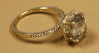 A 4.06 carat Cushion cut diamond, set in yellow gold Halo setting surrounded by diamonds.