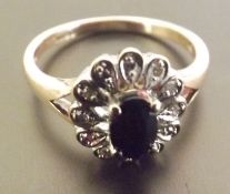 A saphire and diamond ring, A single stone sapphire ring suuround by illusion set diamonds, set in 9