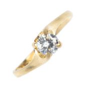 A diamond single-stone ring. The brilliant-cut diamond, to the asymmetric shoulders. Estimated