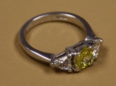 A 0.81 certified Cushion cut Yellow diamond, accomanied by a further two trillion cut diamonds set