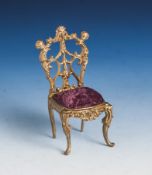 Taschenuhrenhalter in Form eines Stuhles, Metall, Sitzfläche gepolstert. H. ca. 11 cm.