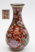 A Chinese porcelain vase: of pear shaped form decorated with dragons amongst peony and other blooms