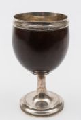 A George III silver mounted coconut cup: of plain form with reeded border,