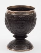 A late Georgian silver mounted coconut cup: with four circular cartouches with monogram,