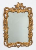 A carved giltwood cartouche shaped mirror:, the plate within a moulded scroll,