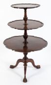 A carved mahogany graduated circular three-tier dumb waiter:,in the Georgian taste,