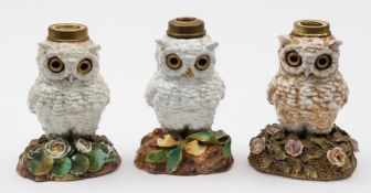 Three  Whittmann & Roth porcelain 'owl' table lamps: each with inset glass eyes comprising a pair
