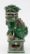 A Chinese famille verte biscuit Buddhist lion: decorated in green,